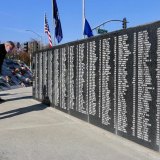 Visitors used time before the Tuesday's ceremony to look up friends and relatives at the wall set aside for veterans.
